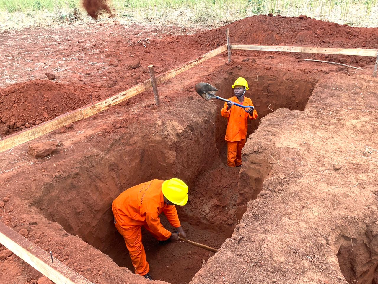 Two workers preparing the ground with shovels
