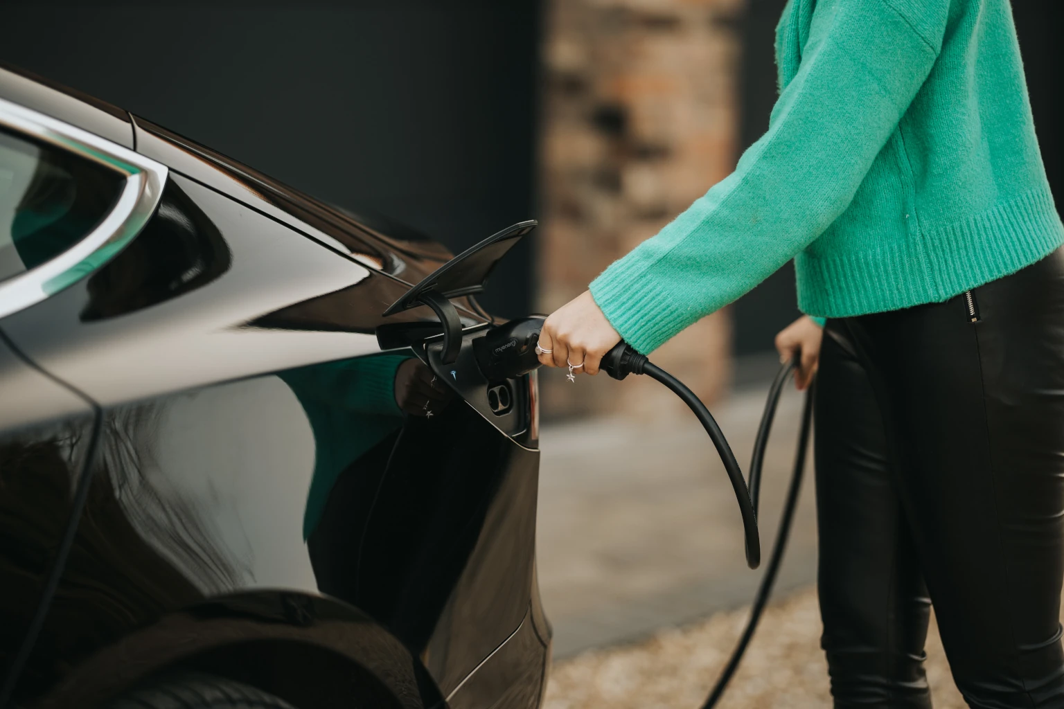 Woman plugging zappi in to electric car